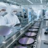 Semiconductor engineers inspect a clean 300mm wafer production line in Japan without logos or readable text.
