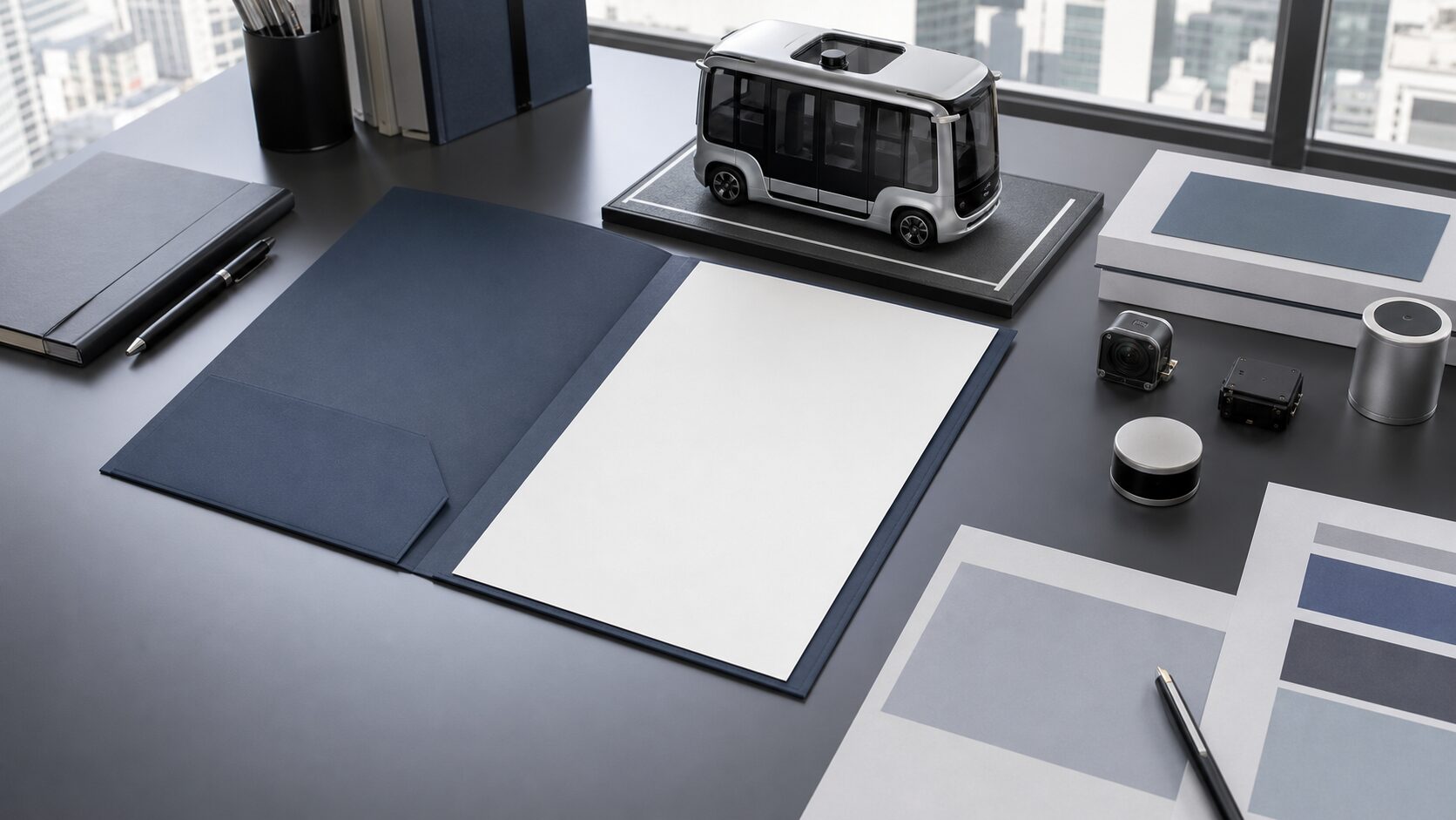 A blank IPO briefing folder sits beside a small autonomous shuttle model and neutral market documents.