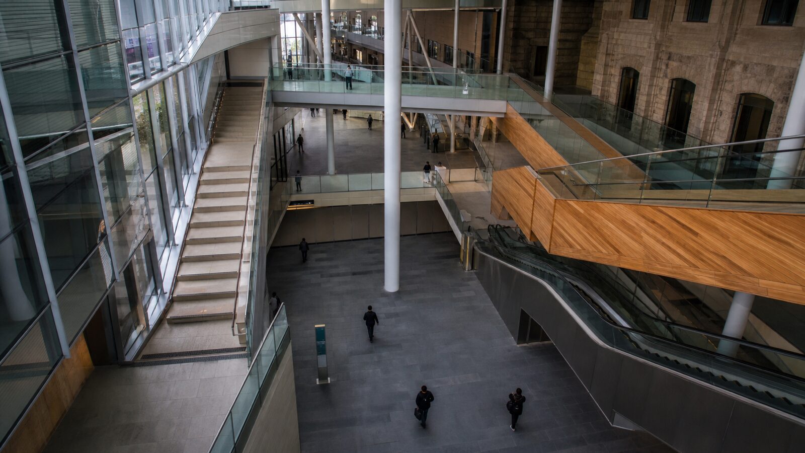 Glass, stone, wood and steel passageways converge inside a large public atrium.