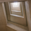 Four concrete landings rise through a skylit office stairwell.