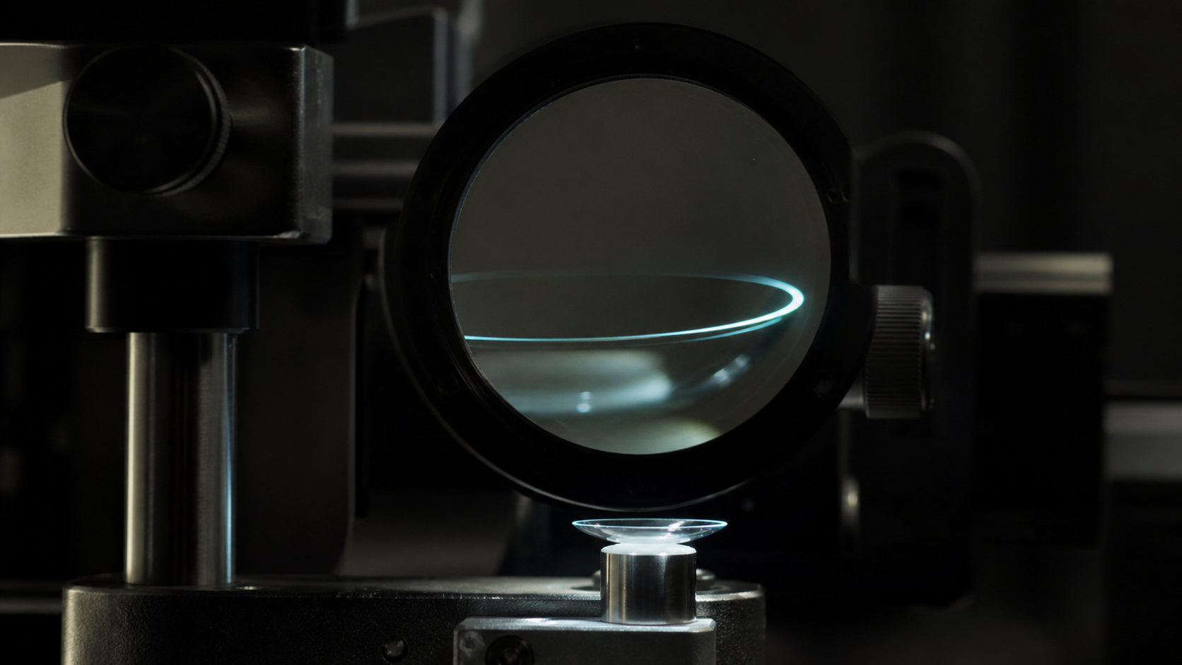 A contact lens edge is magnified under an optical comparator in a dark quality-control laboratory.
