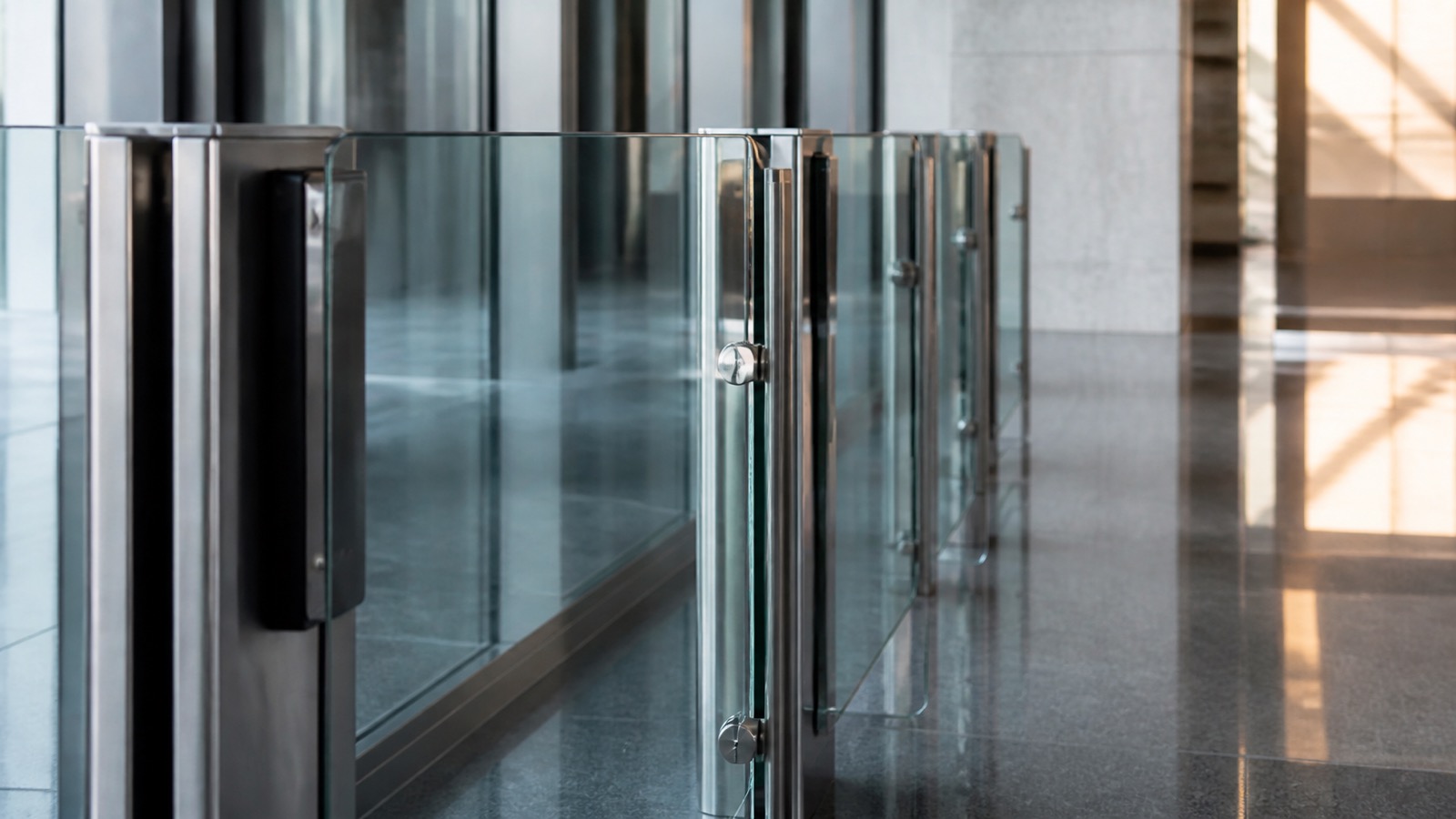 Close view of an unbranded glass access gate in a financial operations building.
