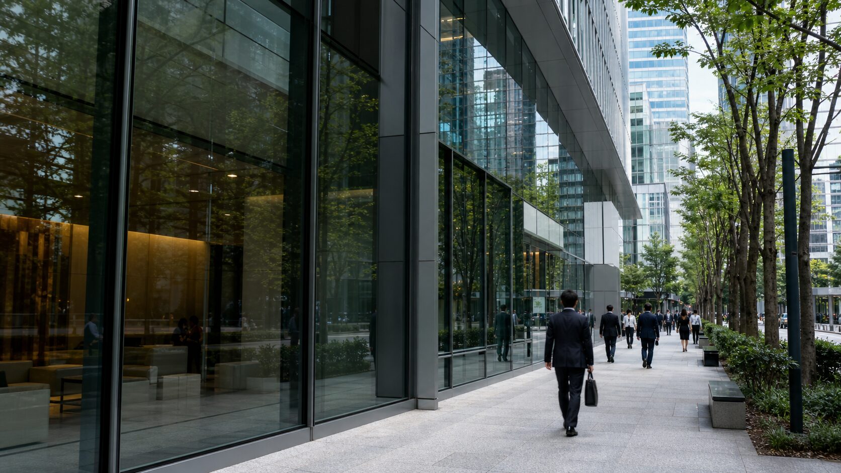 Business pedestrians walking beside glass office buildings in a Tokyo financial district without visible signs