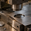 Precision metal blanking press with a circular cutout in a steel sheet