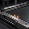 Unbranded rectangular photomask resting in a stainless-steel reticle carrier under cleanroom light