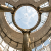 Bronze structural supports framing a circular glass oculus in a modern atrium