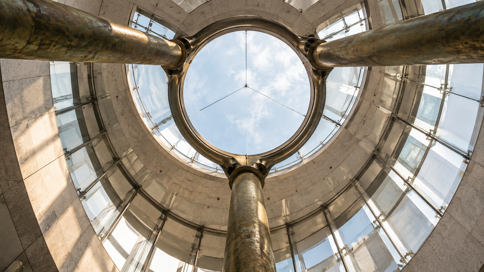 Bronze structural supports framing a circular glass oculus in a modern atrium