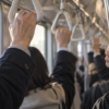 Commuters holding train straps during an early morning journey