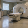 An unbranded CT scanner in a quiet hospital imaging room, seen through an open doorway.